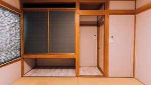 A traditional Japanese room with tatami flooring, sliding doors, and wooden beams. - 3BD Yuzawa Onsen Lodge House A (Minamiuonuma)