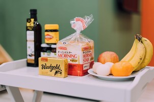 A tray with bread, eggs, a banana, a bottle, and a jar.