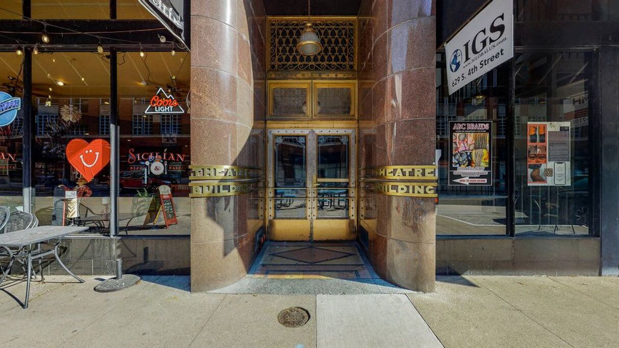 L’entrée d’un hôtel, avec une porte en verre, une décoration en forme de cœur et une enseigne indiquant « Coors Light ».