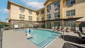 A hotel with a swimming pool, outdoor seating, and a 'No Swimming' sign. - Fully Furnished Hotel Suites in Las Vegas with Fitness Room and Outdoor Pool (Las Vegas)