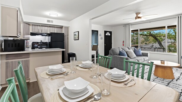 Una cocina moderna con comedor, un sofá y vistas al exterior.