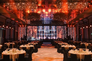 A banquet hall with round tables set for a formal event, featuring a stage with a large screen and decorative lighting. - Intercontinental Changchun High Tech Zone (Changchun)