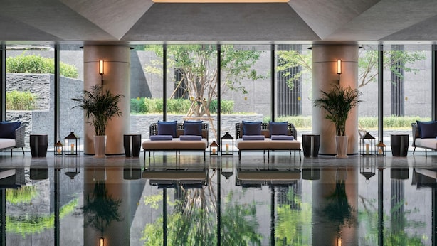 A modern lobby with a reflective floor, large windows, and a seating area with sofas and potted plants. - Intercontinental Changchun High Tech Zone (Changchun)