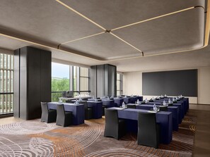 A conference room with multiple tables, chairs, and a large screen. - Intercontinental Changchun High Tech Zone (Changchun)