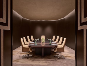 A conference room with a large oval table, beige leather chairs, and a carpeted floor. - Intercontinental Changchun High Tech Zone (Changchun)