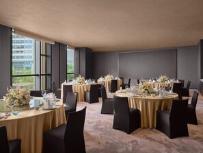 A conference room with multiple tables set for a formal event, featuring black chairs, gold tablecloths, and floral centerpieces. - Intercontinental Changchun High Tech Zone (Changchun)