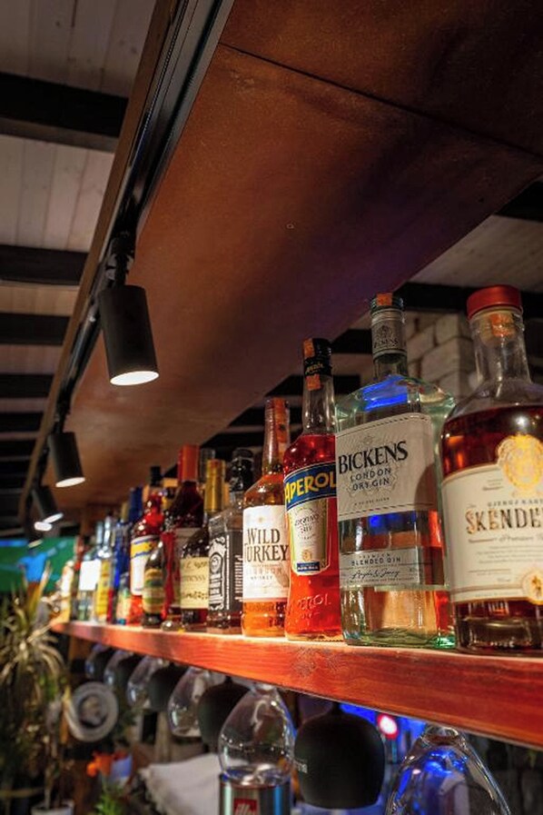 A bar with various liquor bottles and glasses. - Hotel Nika Radhime (Vlorë)