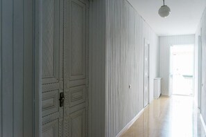 A hallway with white paneled walls and a wooden floor. - Hotel White House (Tbilisi)
