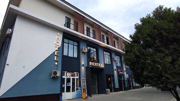 A hotel with a modern facade, large windows, and a sign indicating it is open.