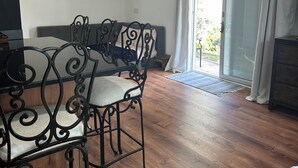 A dining area with a table and chairs, a sofa, and a sliding glass door leading to an outdoor area. - Cool 1- bedroom studio with AC in Spring Lake (Spring Lake)