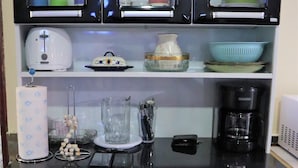 A compact kitchen with black cabinets, a coffee maker, and a toaster.