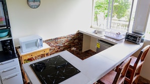 A compact kitchen with a microwave, toaster, and sink.