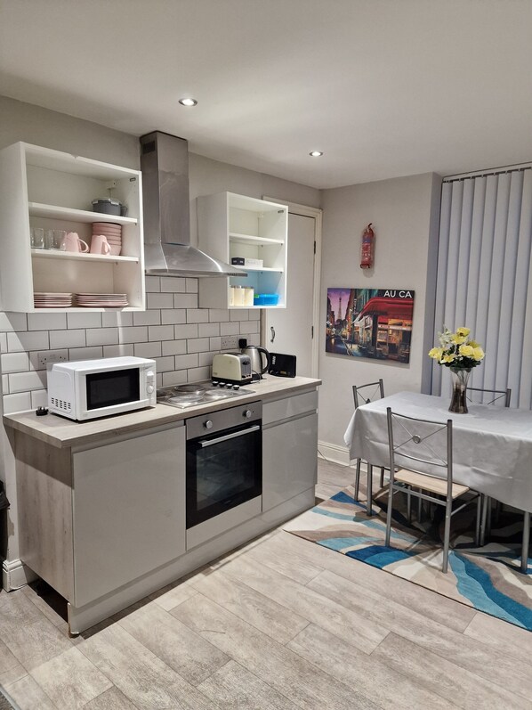 Een magnetron, een oven, een waterkoker, eettafels