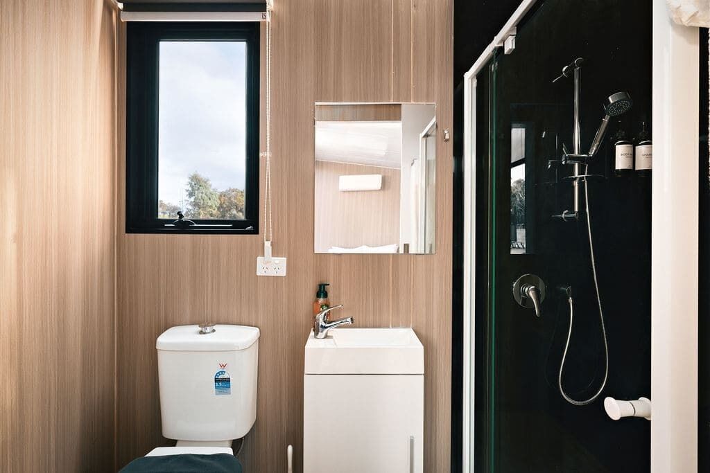 Ein modernes Badezimmer mit Toilette, Waschbecken und Dusche.