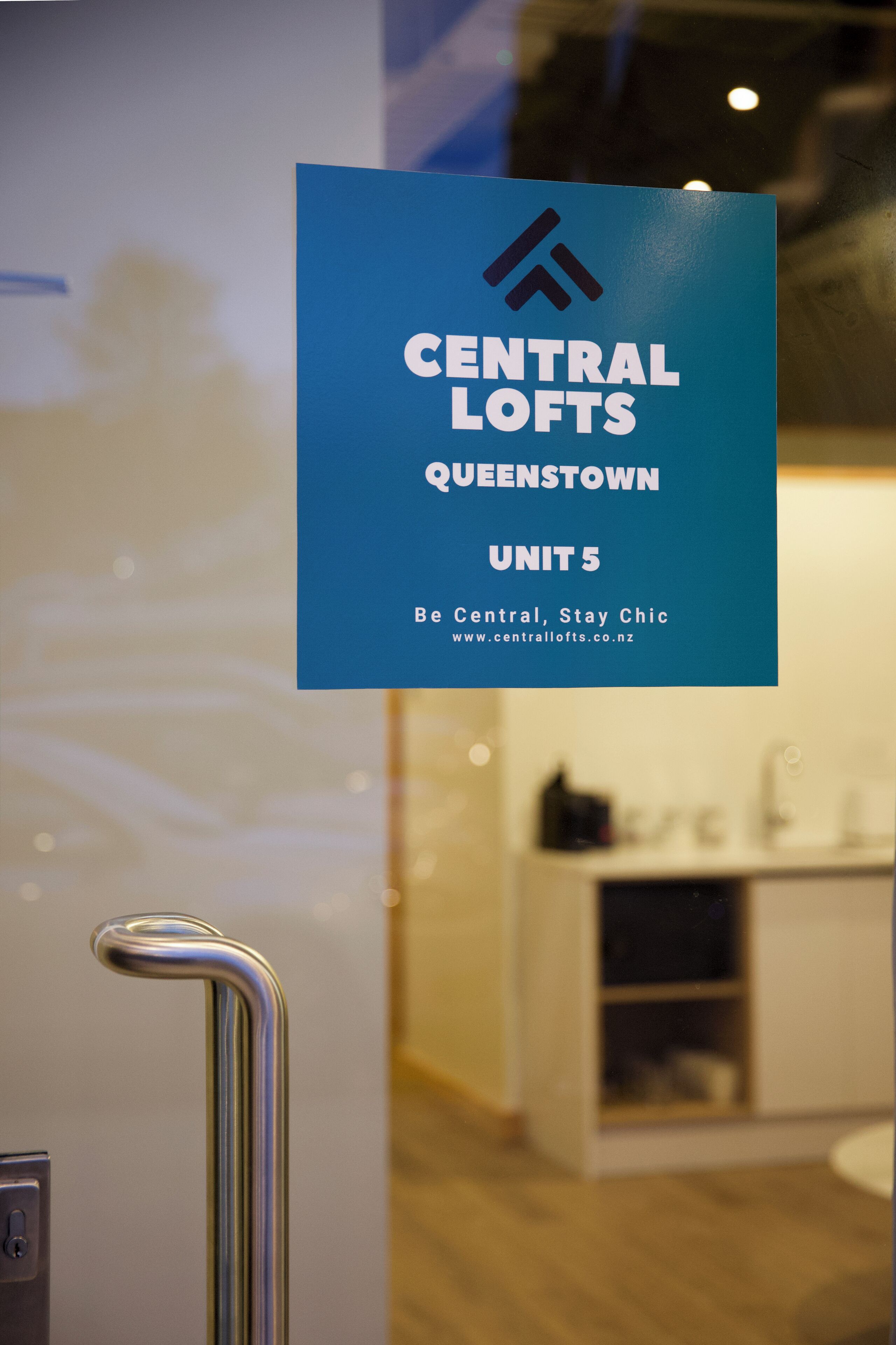 Placa indicando Central Lofts Queenstown com endereço de site.