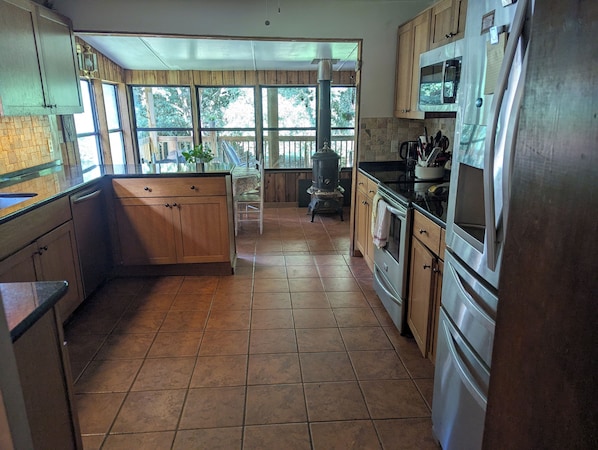 A kitchen with wooden cabinets, a stove, and a refrigerator.