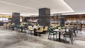 A modern hotel lobby with marble flooring, neatly arranged tables and chairs, and a reception area in the background. - Days Hotel by Wyndham Zhengzhou Zhengdong New District (Zhengzhou)