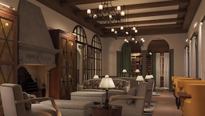 A library reading room with bookshelves, comfortable seating, and a chandelier.