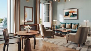 A modern living room with a round wooden table, two armchairs, a sofa, and a large window with curtains. - Borgo Pignano Florence (Florence)