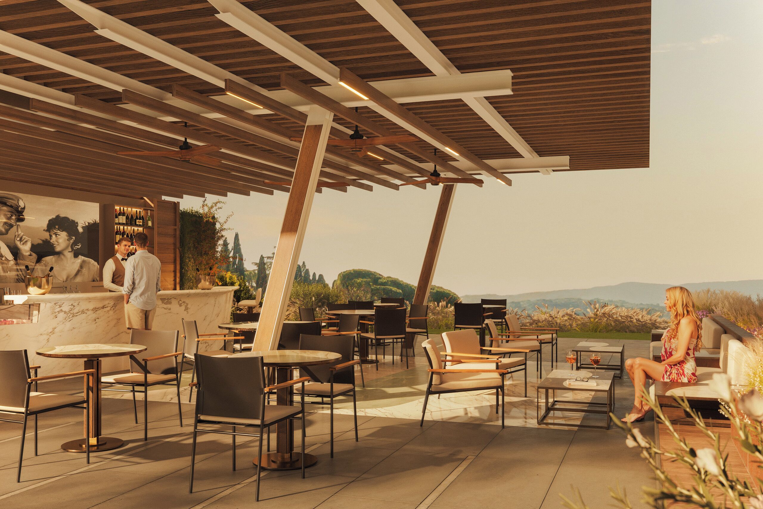 Un espacio al aire libre con mesas y sillas, una barra con un bartender, y vistas del paisaje.