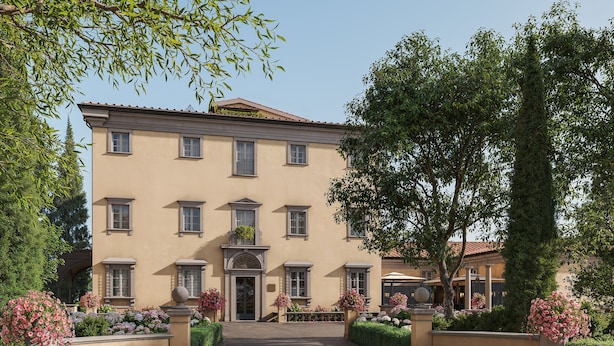 A large, multi-story building with a symmetrical facade, a central entrance, and a well-maintained garden with various plants and flowers. - Borgo Pignano Florence (Florence)