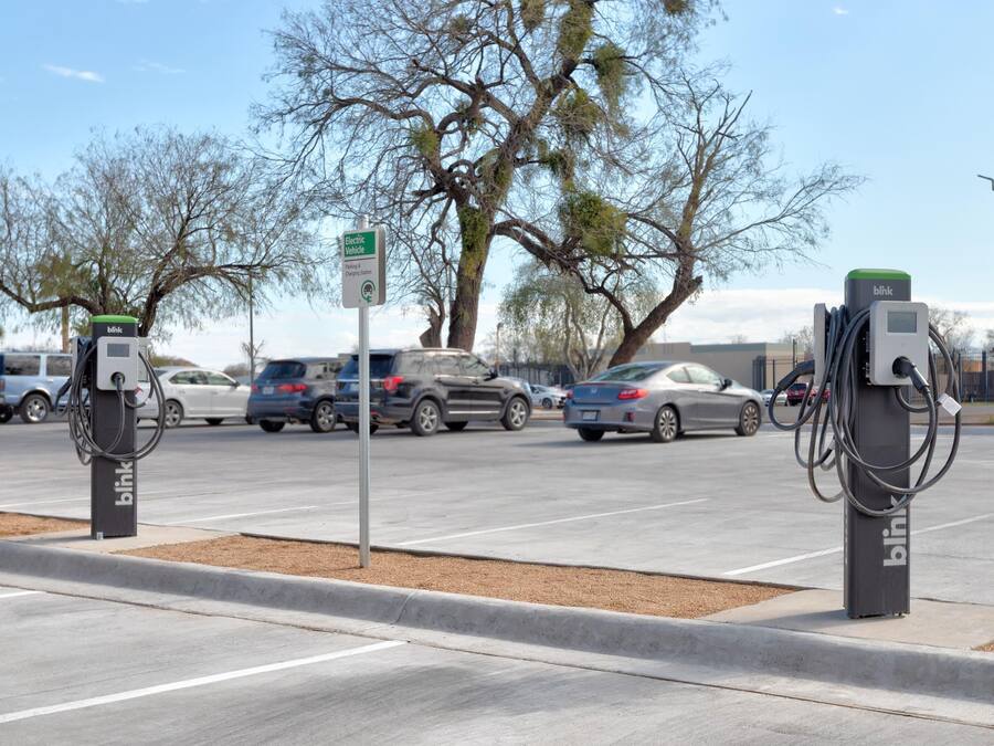 Una estación de carga para vehículos eléctricos con un cartel que indica su uso exclusivo para coches eléctricos.