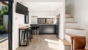A modern kitchen with a central island, built-in appliances, and a dining area with bar stools.