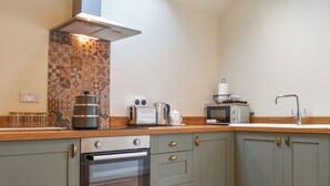 A kitchen with a built-in oven, a microwave, a toaster, and a kettle on the countertop. - 1 bedroom accommodation in Earl Sterndale, near Buxton (Earl Sterndale, near Buxton)