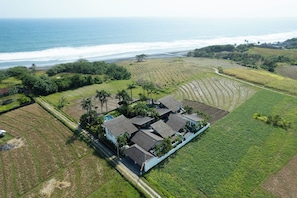 An aerial view of a coastal property with a house surrounded by fields and a beach. - Boutique Villas Breeze 4 bedroom including chef and daily breakfast (Tabanan)
