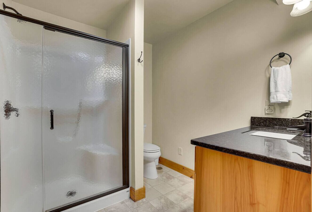 Une salle de bain avec douche, toilettes et lavabo.
