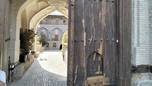 An arched doorway leading to a courtyard with a building in the background. - Hotel Caravansaray Rashid in Bukhara  (Bukhara)