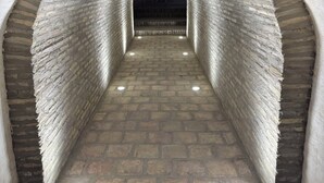 A stone tunnel with a brick archway and a paved floor. - Hotel Caravansaray Rashid in Bukhara  (Bukhara)