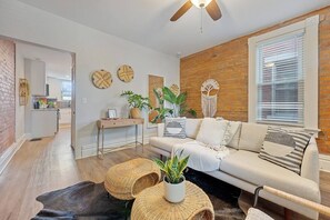 Een moderne woonkamer met een bank, salontafel en decoratieve accessoires.