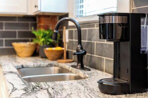 A kitchen with a coffee maker, a sink, and potted plants. - Chic Columbus Retreat with Reserved Parking (Columbus)