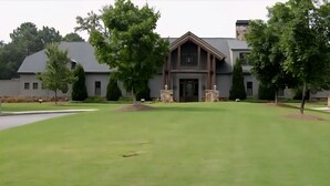 A large, modern building with a symmetrical facade, a central entrance, and a well-maintained lawn in front. - 4-bedroom house in charming Timberline Golf neighborhood with pool (Calera)