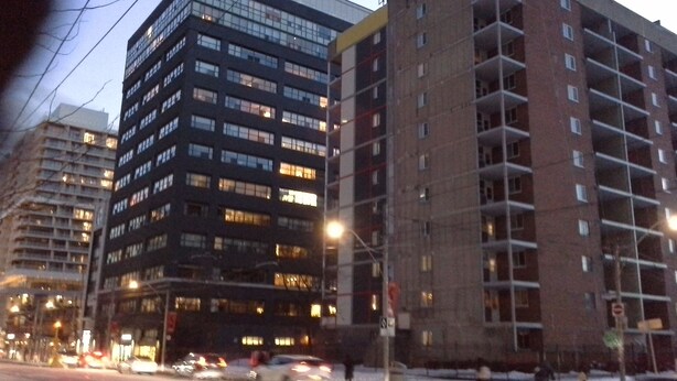 Un edificio de varios pisos con un diseño arquitectónico moderno, con múltiples ventanas y balcones.