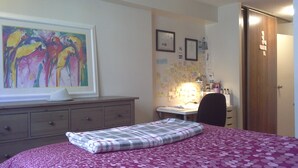 Un dormitorio con una cama, un escritorio y un aparador.