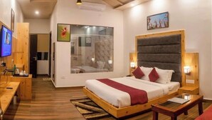 Ein modernes Schlafzimmer mit einem großen Bett, einem Holz-Kopfteil, Nachttischlampen und einem Fernseher auf einem Holztisch.