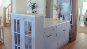 A kitchen with a white cabinet, a refrigerator, and a staircase leading to another room. - New renovation Moon River (Marine City)