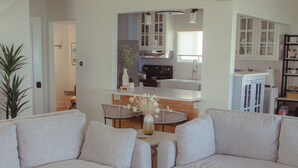 A modern living room with two sofas, a coffee table, and a kitchen in the background. - New renovation Moon River (Marine City)