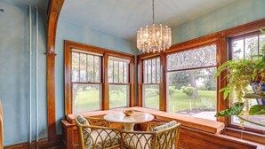 A room with a wooden table and chairs, large windows with a view of a garden, and a hanging light fixture. - Fire Pits, Views & Yard: Luxe Mt Horeb Getaway! (Mt Horeb)
