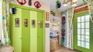 A room with a green door, a small table, and a hanging plant. - Outdoor Bar & Large Pool: Retro ABQ Retreat! (Albuquerque)