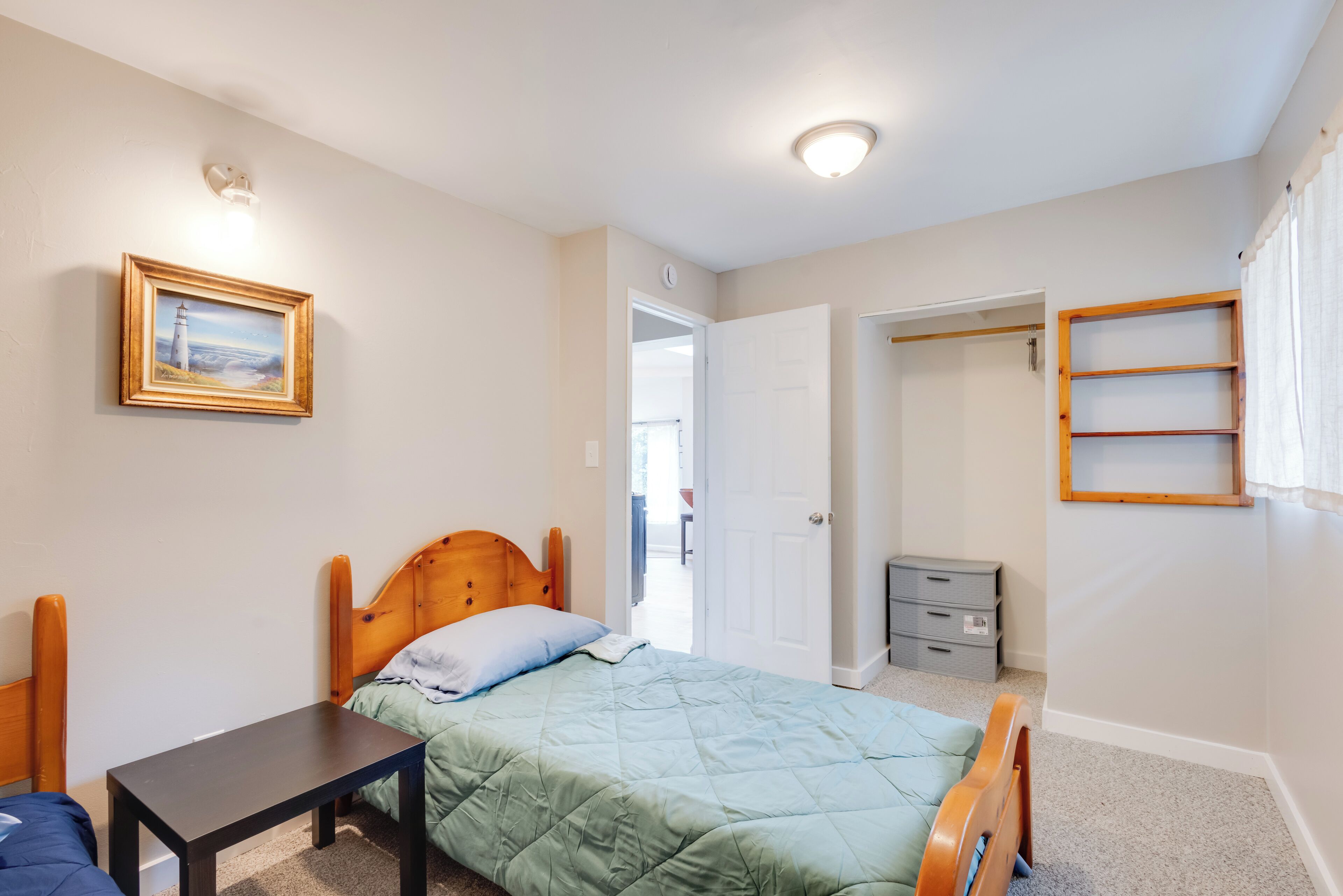 A bedroom with a bed, bedside table, and a wardrobe.