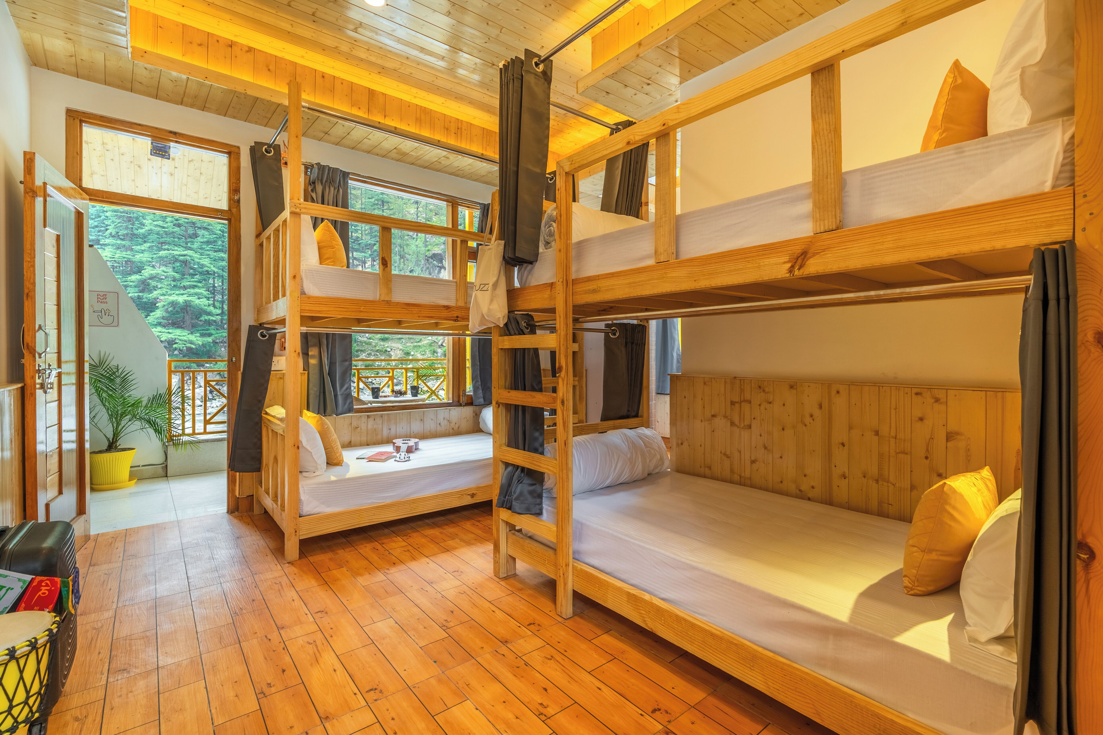Interior de madera con literas, un rincón de descanso con cojines y vistas al exterior.