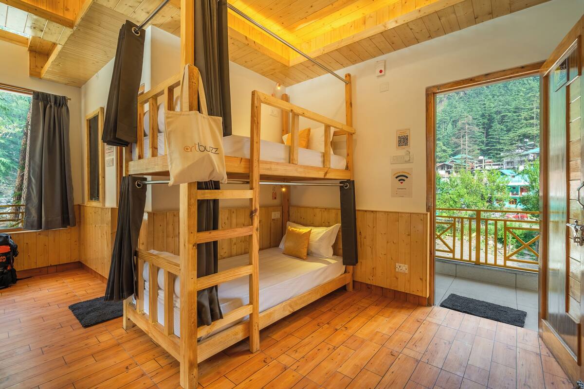 A wooden bunk bed room with a view of a forested area.