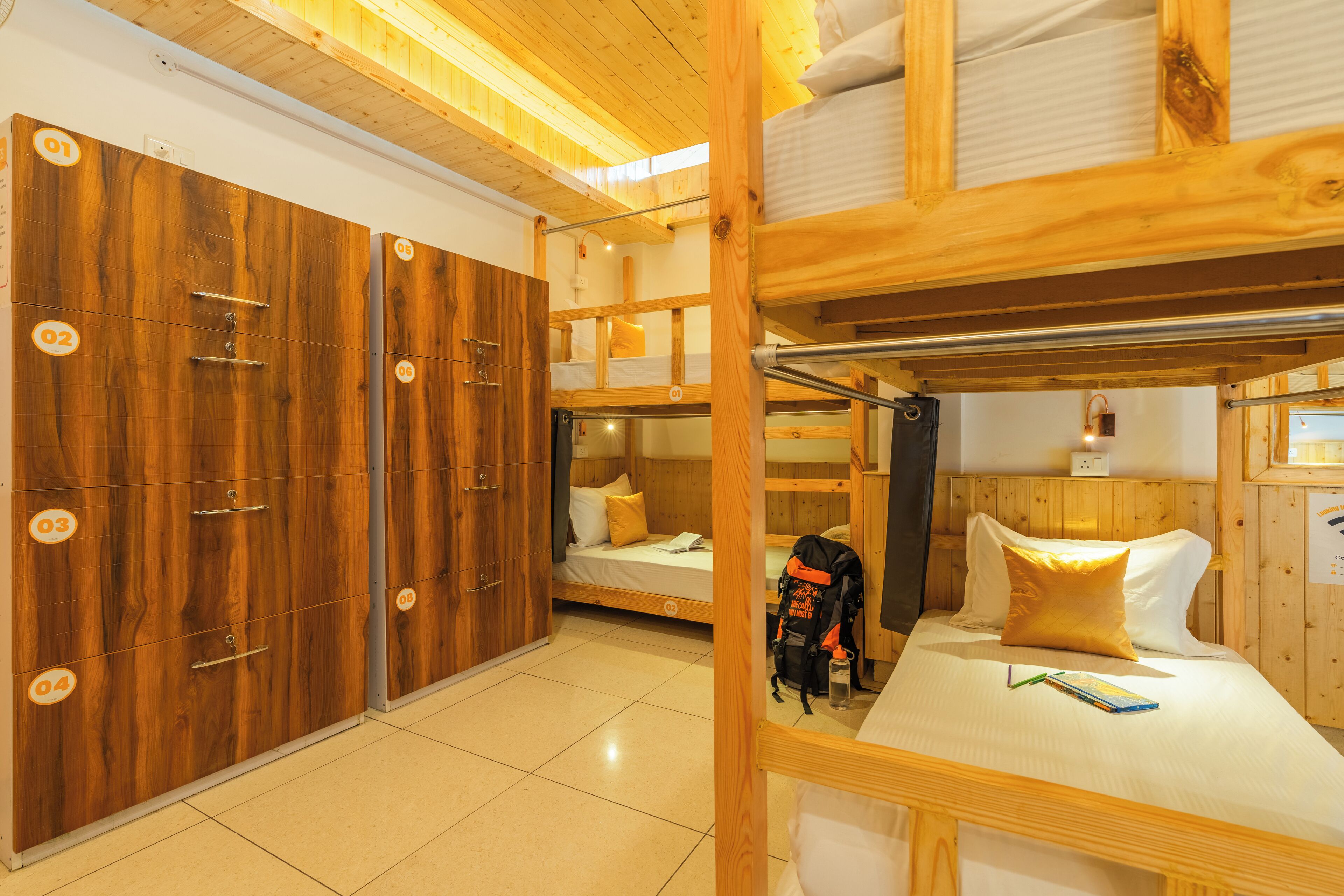 A room with bunk beds, wooden wardrobes, and a tiled floor.