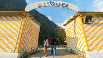 Entrada de un edificio con un letrero que dice 'artbuzz' y un patrón de pared de ladrillos.