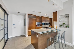 Una cocina moderna con una isla central, electrodomésticos de acero inoxidable y un salpicadero de vidrio.