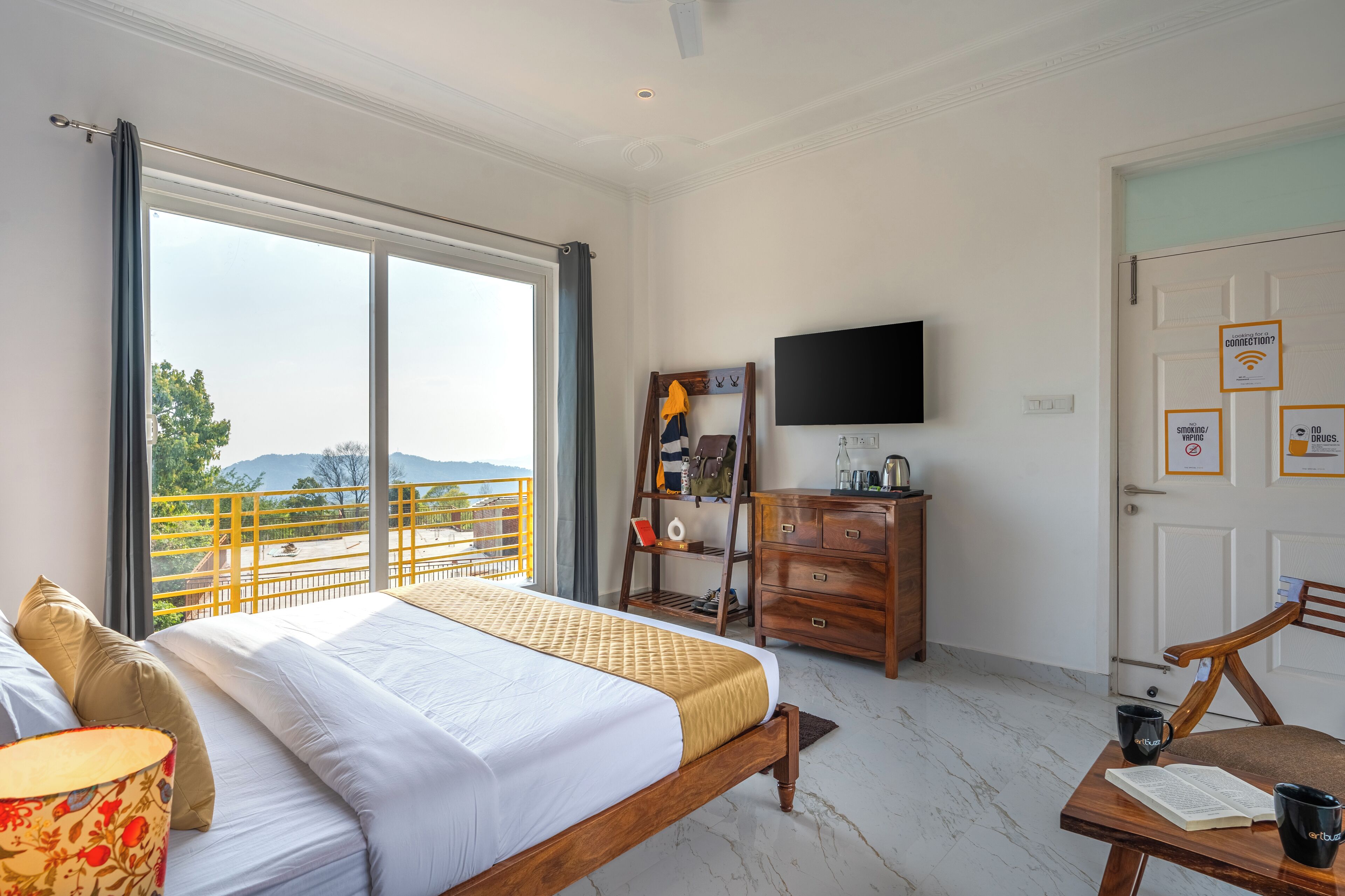 Une chambre à coucher comprenant un lit, une télévision, une commode et un balcon avec vue.