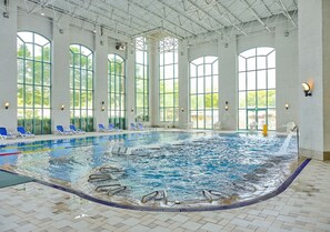 An indoor swimming pool with clear water, surrounded by lounge chairs and large windows. - Oakvalley Resort Hills Village (Wonju)